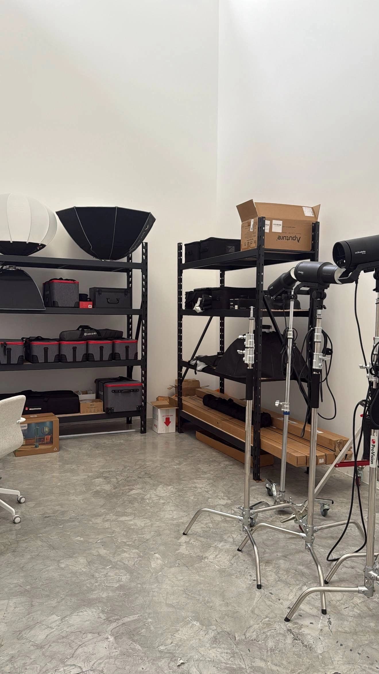 Lighting cases, softboxes and Profoto heads on shelves and stands in the BlueSky Studio equipment room